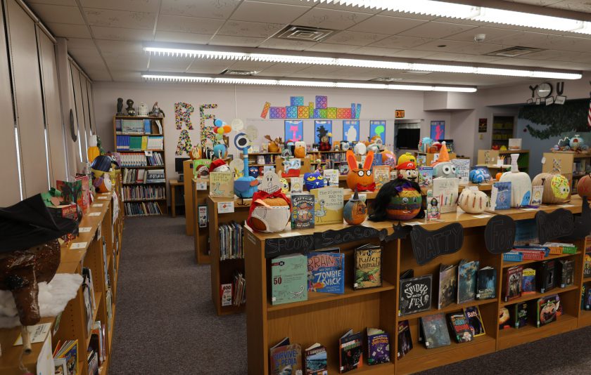 decorated pumpkins on library bookshelves