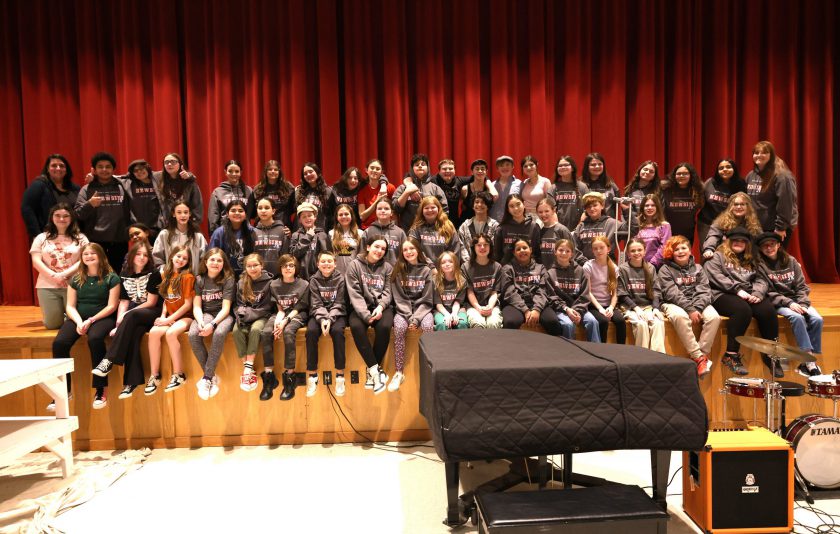 student actors sitting on stage grouped together